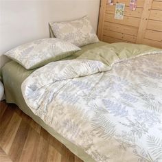 a bed with two pillows on top of it next to a wooden headboard in a bedroom