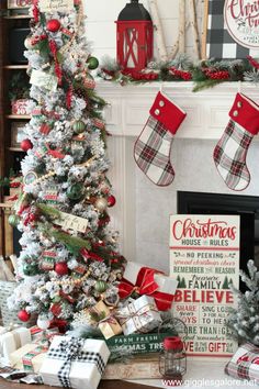 a decorated christmas tree with stockings and stockings hanging from the mantle in front of it