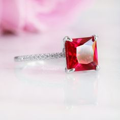 Gorgeous Princess Cut Ruby Ring ►Made of solid sterling silver with rhodium finish (925) ►Accented with simulated diamonds (CZ) ►Average band width: 1.4 mm Center Stone: Ruby Gemstone creation: 100% genuine lab-grown ruby Shape: Princess Gem size: 8.0 x 8.0 mm Carat Weight: 3 ct. (diamond equivalent) Hardness: 9 (Mohs scale) ✓ 100% Nickel-Free ✓ Hypoallergenic ✓ Comfort Fit ✓ Free Ring Box ✓ Free USA Shipping ✓ Ready to ship next business day Mohs Scale, Moonstone Engagement Ring, Ruby Engagement Ring, Ruby Gemstone, Fine Jewelry Collection, Anniversary Gift For Her, Gemstone Engagement Rings, Ruby Ring, Womens Engagement Rings