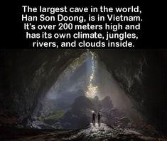 two people standing in the middle of a cave with light coming from it's entrance