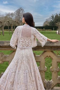 This jacket lehenga set features embroidery in white and silver sequin and crystal on a nude base. The strappy blouse is fully embroidered and shows tassels at the waist. The ensemble is paired with a matching flowy jacket.From Seema Gujral's A Royal Affair collection. DELIVERY TIMEPlease allow 8-12 weeks for your outfit to arrive. FABRIC DETAILSNet Professional cleaning only. Bohemian Sequin Sets For Reception, Elegant Embroidered Choli For Spring, Bohemian Sequin Wedding Sets, Bohemian Wedding Sets With Sequins, Wedding Sets With Tassels And Fitted Design, Fitted Wedding Sets With Tassels, Elegant Spring Choli With Intricate Embroidery, Elegant Embroidered Spring Choli, Floor-length Wedding Sets With Tassels