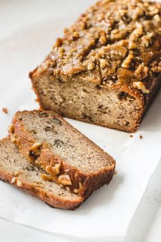 two slices of banana nut bread sitting on top of white paper next to each other