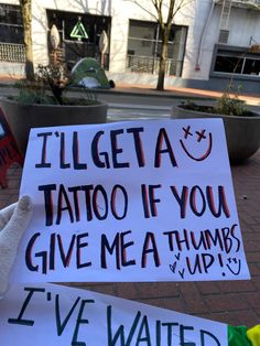 two signs that say i'll get a tattoo if you give me a thumbs up