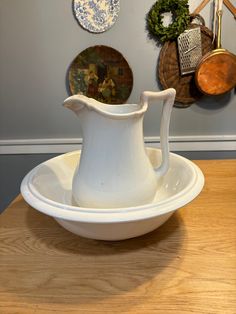 a white pitcher sitting on top of a wooden table