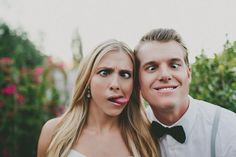 a man standing next to a woman with long blonde hair and wearing suspenders, posing for a black and white photo