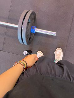 a person with their feet on the ground next to a barbell