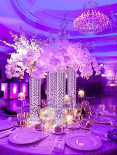 a purple table setting with flowers and candles