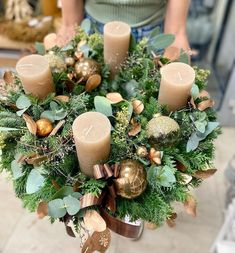 a person holding a bouquet with candles and greenery