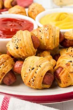 hot dogs wrapped in croissants on a plate with dipping sauce