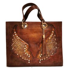 Boasting a beautifully chiseled artisan design, this rustic hand-tooled leather bag adds a touch of vintage elegance to your daily ensemble. Ideally sized to hold all your essentials, this purse is genuinely handmade with love and care by skilled artisans, offering a unique rustic charm that's a rare find in commercial stores. CHISELED leather with angel's wing design. Height: 30 cm (12 inches) Width: 38 cm (15 inches) Base: 13 cm (5 inches) Handle Straps: 6.5 inches Fabric Lining Interior extra Tooled Leather Handbags, Bohemian Cowgirl, Angel Wings Design, Woman Hand, Tooled Leather Bag, Wing Design, Raw Leather, Handbags Tote, Vintage Elegance