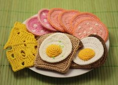 small crocheted food items on a plate with green table cloth and bamboo mat