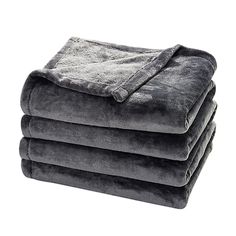 four blankets stacked on top of each other in grey color, with one blanket folded over it