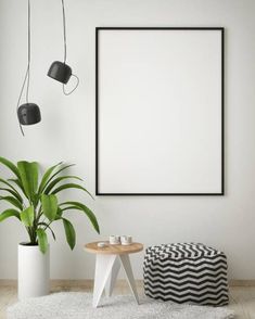 a living room with white walls, black and white furniture and a large poster hanging on the wall