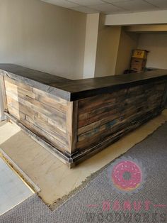 a large wooden counter sitting in the middle of a room with a donut sign on it