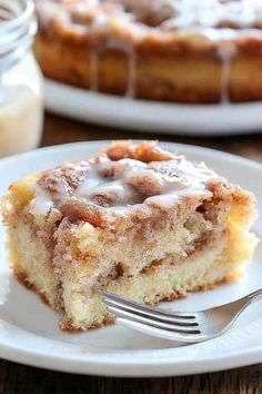 a piece of cinnamon roll cake on a plate with a fork next to the slice