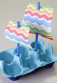 an egg carton with a paper boat in it