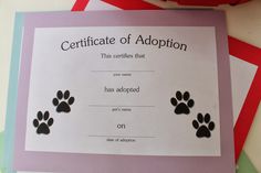 a certificate with three paw prints is on top of some folded papers and two red folders