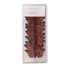 an orange butterfly with black spots on it's wings in a cardboard packaging box