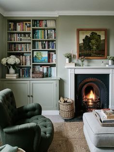 a living room filled with furniture and a fire place in front of a bookshelf