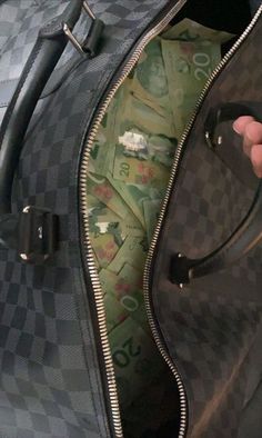 a person holding onto a piece of luggage with money sticking out of the inside of it