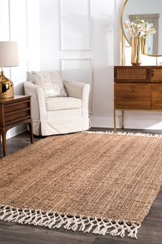 a living room with a rug, chair and mirror on the wall in front of it