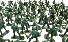 a group of toy army men standing next to each other on top of a white surface