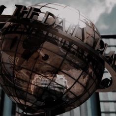 a globe with the words world trade center written on it's face and in front of a tall building