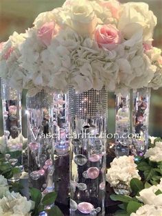 there are many tall vases with flowers in them on the table at this wedding reception