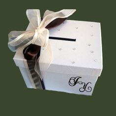 a white gift box with a ribbon and monogramming on the side, tied with a bow