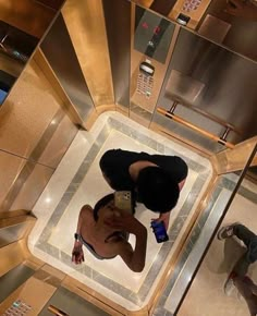 a woman is taking a selfie in an elevator with her cell phone and water bottle