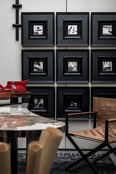 a black and white room with chairs and pictures on the wall, including a table