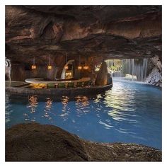 the inside of a cave with a pool and waterfall