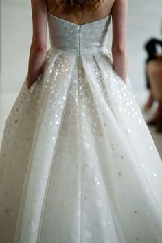 the back of a woman's wedding dress with sequins