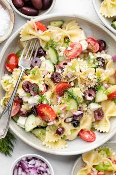 pasta salad with olives, cucumbers, tomatoes and feta cheese on a white plate