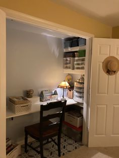 a room with a desk, chair and shelves on the wall next to a door