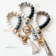 four different bracelets with charms and tassels on them