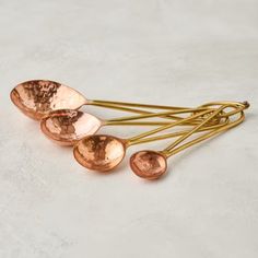 four copper colored spoons sitting on top of each other