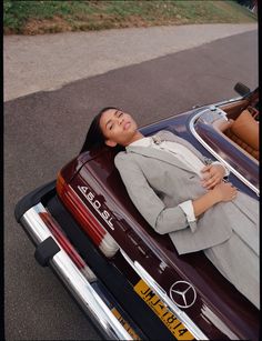 a woman laying on the back of a car