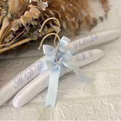 two white wedding garters with blue ribbon tied to them and some dried flowers in the background