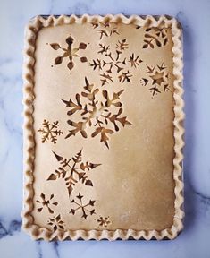 an uncooked pie crust with decorative designs on it