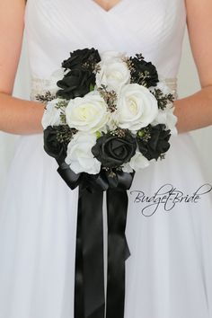 the bride is holding her black and white bouquet