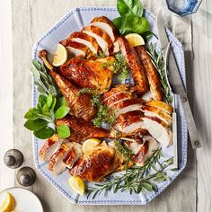 a platter filled with sliced chicken and garnished with herbs