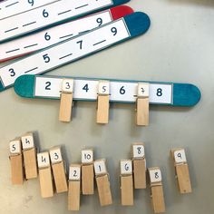 several wooden pegs with numbers on them sitting next to a skateboard and ruler