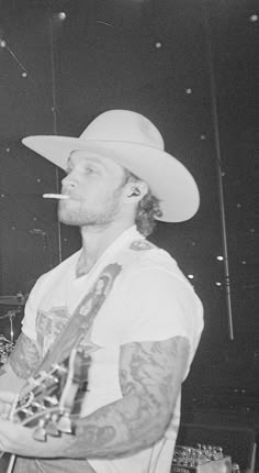 a man wearing a cowboy hat and holding a guitar