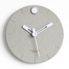 a grey clock with white hands and numbers on the face is shown in front of a white background