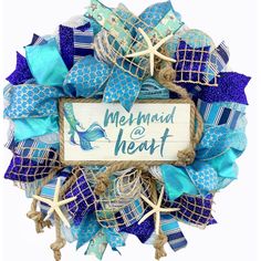 a blue and white wreath with the words mermaid is heart on it