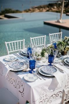 an outdoor table set with plates and place settings