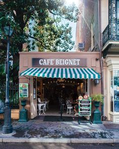 a cafe with green and white awnings on the side of it's building