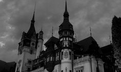 an old building with two towers on top and dark clouds in the sky behind it