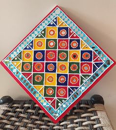 a colorful decorative plate sitting on top of a wicker tablecloth covered place mat